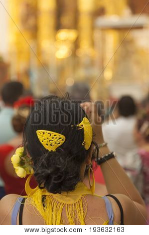 El Rocio Spain - June 2 2017: Female pilgrim in traditional spanish dress in the hermitage of El Rocio during the Romeria 2017. Andalusia Spain