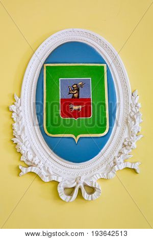MYSHKIN RUSSIA - JUNE 18 2017: City coat of arms in a frame of white stucco. Yaroslavl Region
