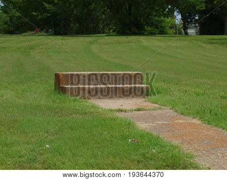 Old cement steps and sidewalk in a vacant lot. The value of the steps seem to surpass the value of the former property.