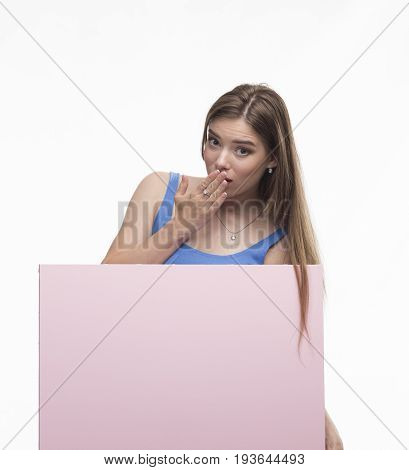 Young spry woman portrait of a confident businesswoman showing presentation, pointing paper placard pink background. Ideal for banners, registration forms, presentation, landings, presenting concept.