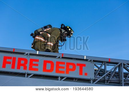 Firefighter Training Entering And Exiting A Building On A Truck Ladder