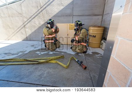 Firefighter Training Entering A Building With A Charged Hose