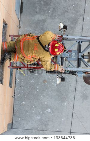 Firefighter Training Entering And Exiting A Building On A Truck Ladder Overhead View