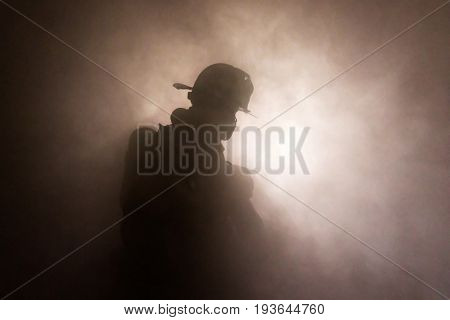 Firefighter In Full Turnouts Silhouetted In Smoke