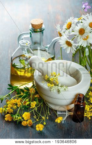 Bottles with natural aroma of essential oils, mortar and wild flowers, Spa concept.