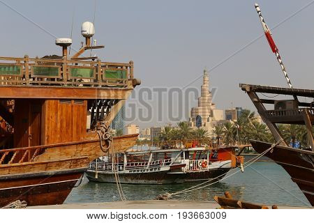 DOHA, QATAR - JULY 3, 2017: The landmark spiral minaret in central Doha seen beyond dhows moored in the bay on the day the Saudi ultimatum to Qatar expired