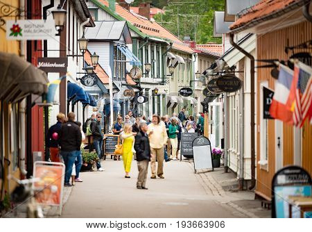Sigtuna Sweden - 23 July 2013: old town street in City of Sigtuna Sweden Europe. Beautiful sunny day with tourists walking in street.