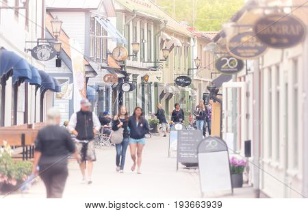 Sigtuna Sweden - 23 July 2013: old town street in City of Sigtuna Sweden Europe. Beautiful sunny day with tourists walking in street.