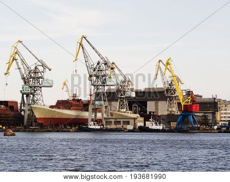 Big ship under repairing on floating dry dock in shipyard.