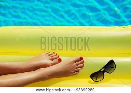Portrait Of Beautiful Tanned Woman Relaxing In Swimming Pool. Sunglasses And Inflatable Matress. Leg