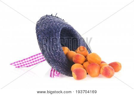 Blue straw summer hat full with fresh abricots