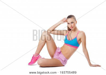Young sportive woman posing in pink sport uniform. Isolated white background