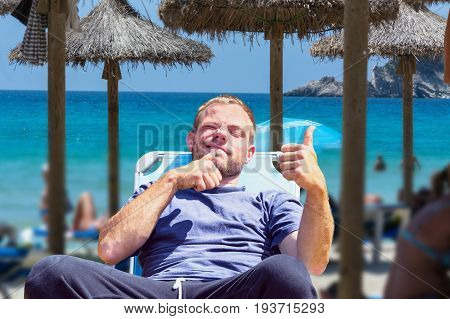 Beach life beach holiday. Focus on man in deck chair. Background desired blur.
