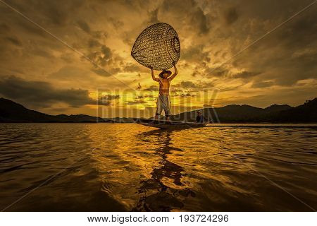 Fishermen are using the fisherman's tools in earnest shining in yellow orange and orange across the sky Freshwater fisherman