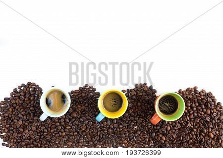 Colorful coffee cups lined up on coffee beans isolated on white background for web banner