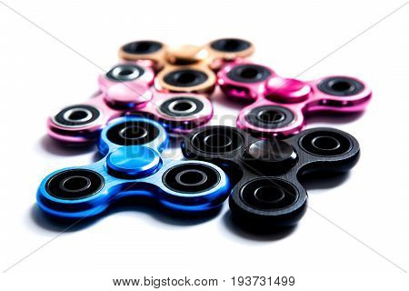 Fidget finger metal spinner anxiety relief toy on white isolated background copyspace. Concept relieving stress