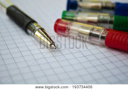 black, blue, red, green pen lying on the notebook