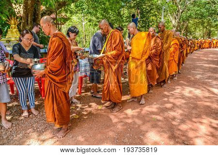 KRABI THAILAND - MAY 3 2015: Thai Buddhists offering food to monks' alms-bowl in Lanta island of Krabi Thailand