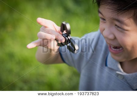 Chld  Playing  Fidget Spinner On Nature Background
