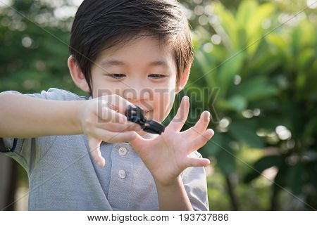 Chld  Playing  Fidget Spinner On Nature Background