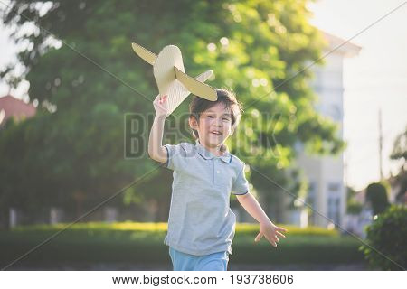 Asian Child Playing Cardboard Airplane