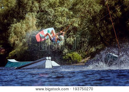 Woman is an extreme in a jump over the water. She trains before the performance.