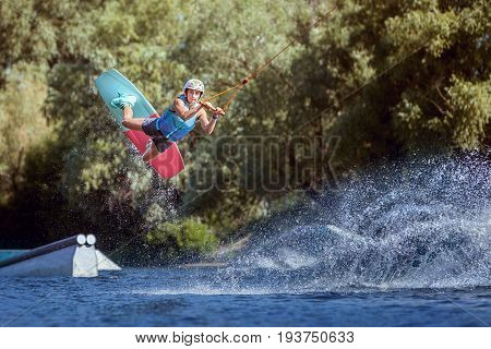 Professional athlete during a wakeboard trick on the water.