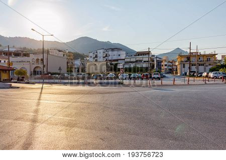 Greece, Corfu port parking place at sunset. Bright sun reflected on ground