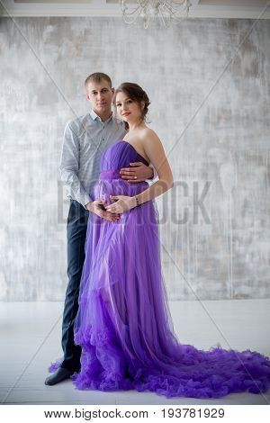pregnant woman and man posing together in Studio, happy waiting