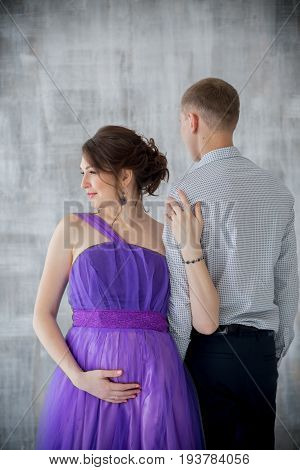 pregnant woman and man posing together in Studio, happy waiting