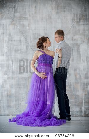 pregnant woman and man posing together in Studio, happy waiting