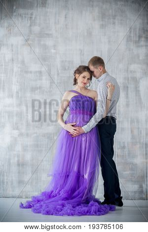 pregnant woman and man posing together in Studio, happy waiting