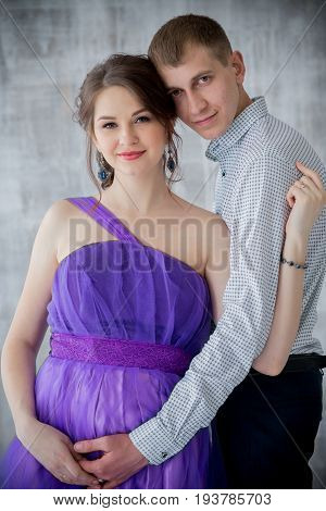 pregnant woman and man posing together in Studio, happy waiting