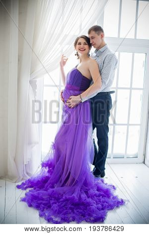 pregnant woman and man posing together in Studio, happy waiting