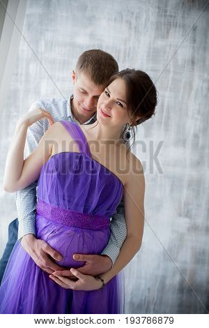 pregnant woman and man posing together in Studio, happy waiting