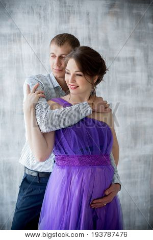 pregnant woman and man posing together in Studio, happy waiting