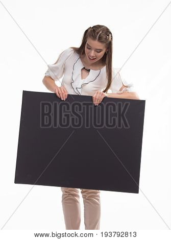 Young jocular woman portrait of a confident businesswoman showing presentation, pointing placard black background. Ideal for banners, registration forms, presentation, landings, presenting concept..