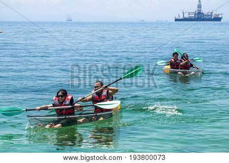 Labuan,Malaysia-May 1,2017:Group of tourist enjoying a weekend kayaking with the transparent kayak in Rusukan Besar island,Labuan,Malaysia.Labuan is the ideal place for water sports,like kayaking & scuba diving