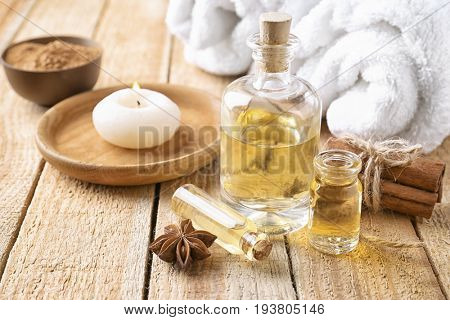 Composition with bottles of cinnamon oil on wooden background