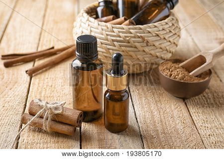 Composition with bottles of cinnamon oil on wooden background