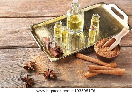 Composition with bottles of cinnamon oil on wooden background