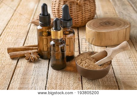 Composition with bottles of cinnamon oil on wooden background