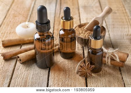Composition with bottles of cinnamon oil on wooden background