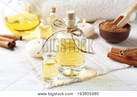 Composition with bottles of cinnamon oil on wooden background