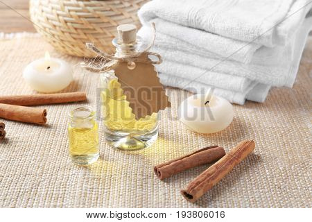 Composition with bottles of cinnamon oil on textile background