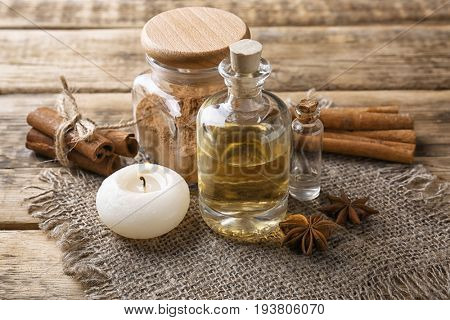 Composition with bottles of cinnamon oil on wooden background