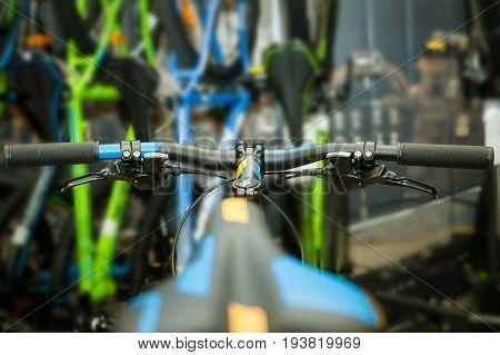 Black bicycle wheel on blurred background in blue-yellow tones