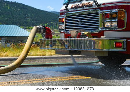 KALISPELL, MONTANA, USA - June 21, 2017: Fire truck pumps water into a hose at scene of a grass fire