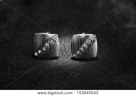 Silver cufflinks with rhinestone on the black matter at the center of the cufflinks catches the light