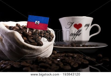 Haitian Flag In A Bag With Coffee Beans Isolated On Black Background
